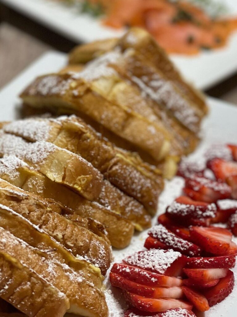 french toast and strawberries with powdered sugar on top