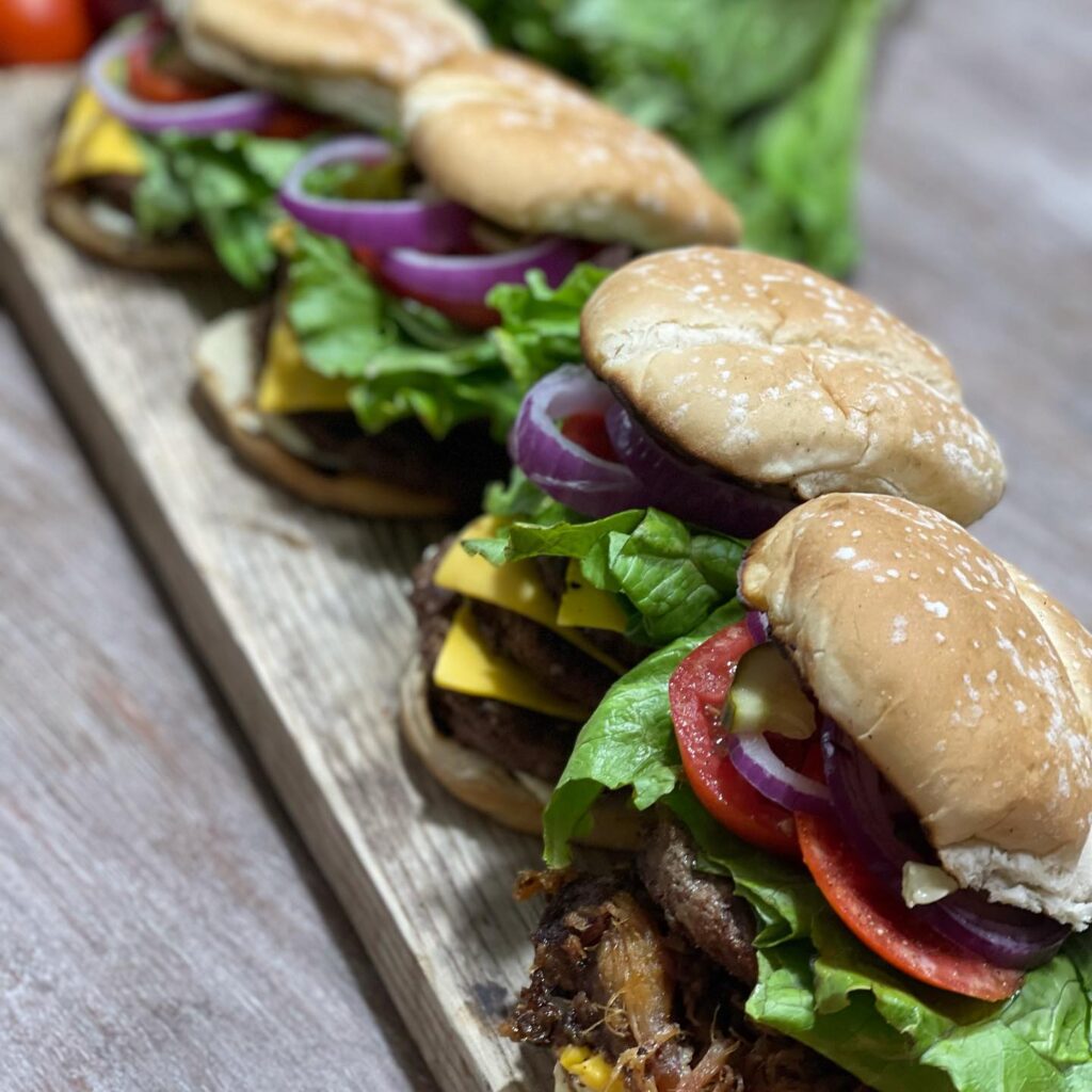 burger sliders displayed on piece of wood
