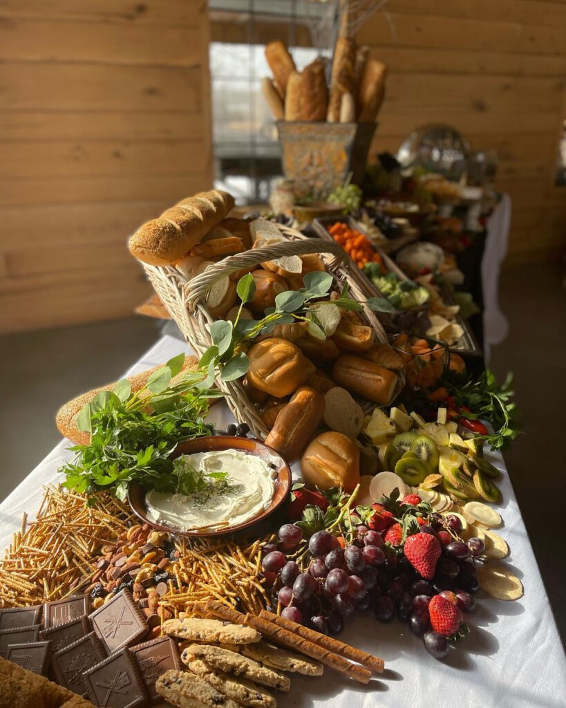 event table with assorted breads, fruits, and vegetables
